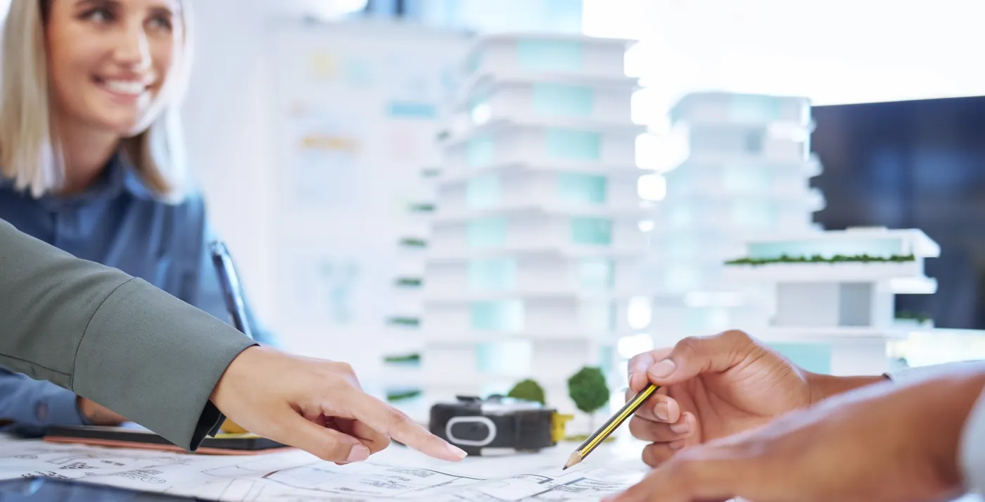 Pessoas reunidas à mesa analisando plantas e documentos