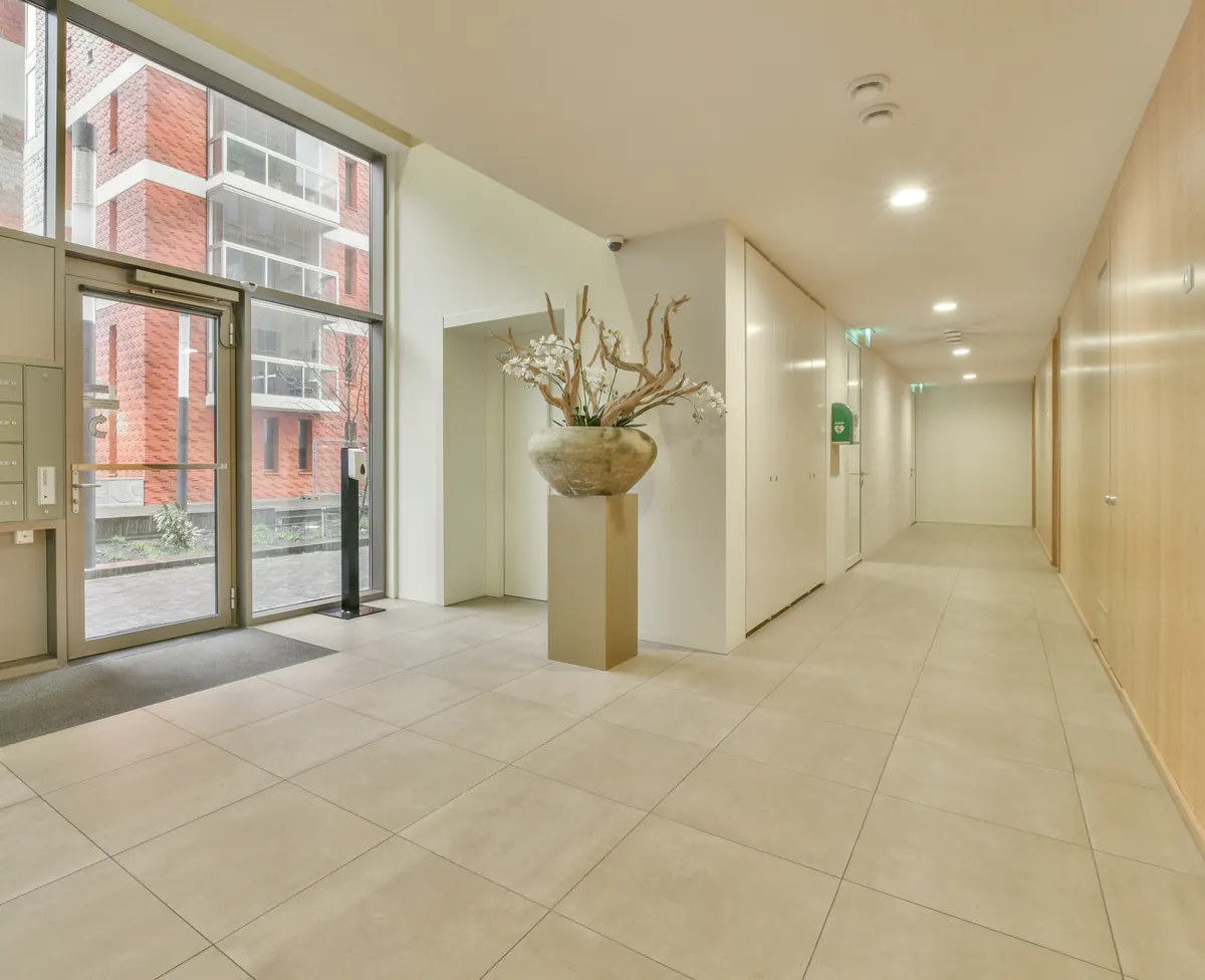 Hall de entrada de condomínio com corredor iluminado